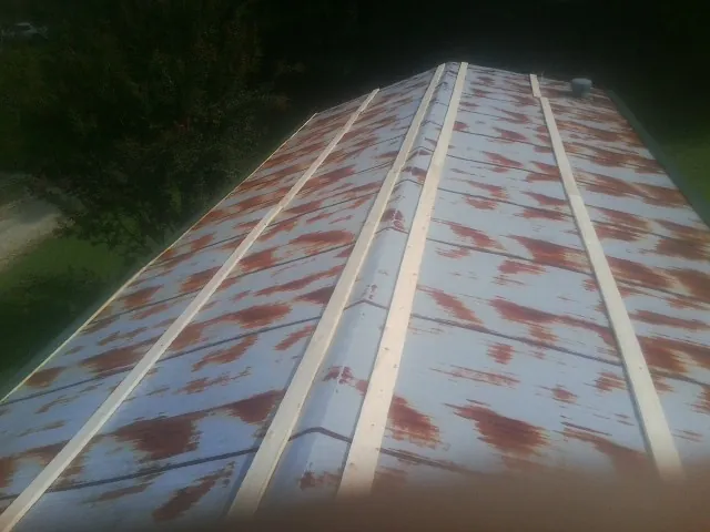 Rusted metal roof panels with new wood purlins before replacement — Storm Damage Roof Repair in Kempner by Roofing Brothers